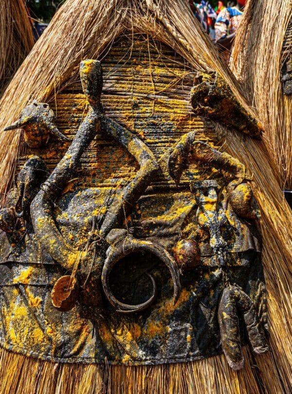 A Zangbeto masquerade in a full raffia costume during a traditional ceremony in Benin