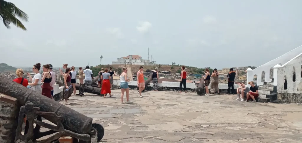 Visitors beside the cannons on the ramparts of Cape Coast Castle, a former slave-trade fort on Ghana coast.