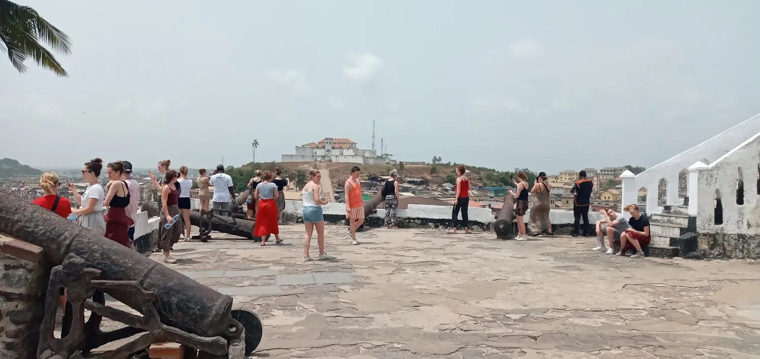 Visitors beside the cannons on the ramparts of Cape Coast Castle, a former slave-trade fort on Ghana coast.