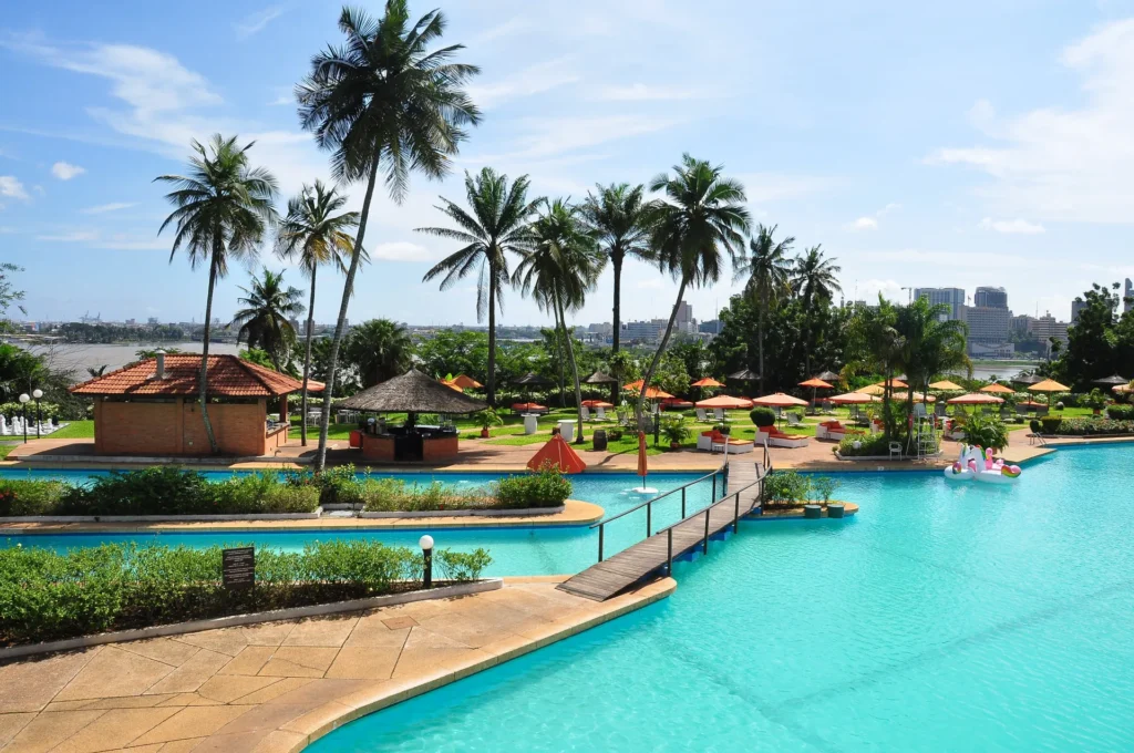 Palm-fringed resort pool near a Cote d'Ivoire lagoon