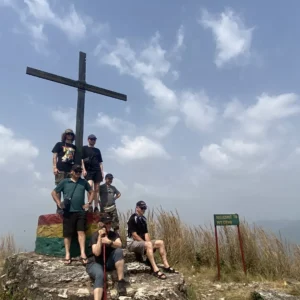 A guided tour group gathered at the summit cross above Amedzofe in Ghana Volta Region.