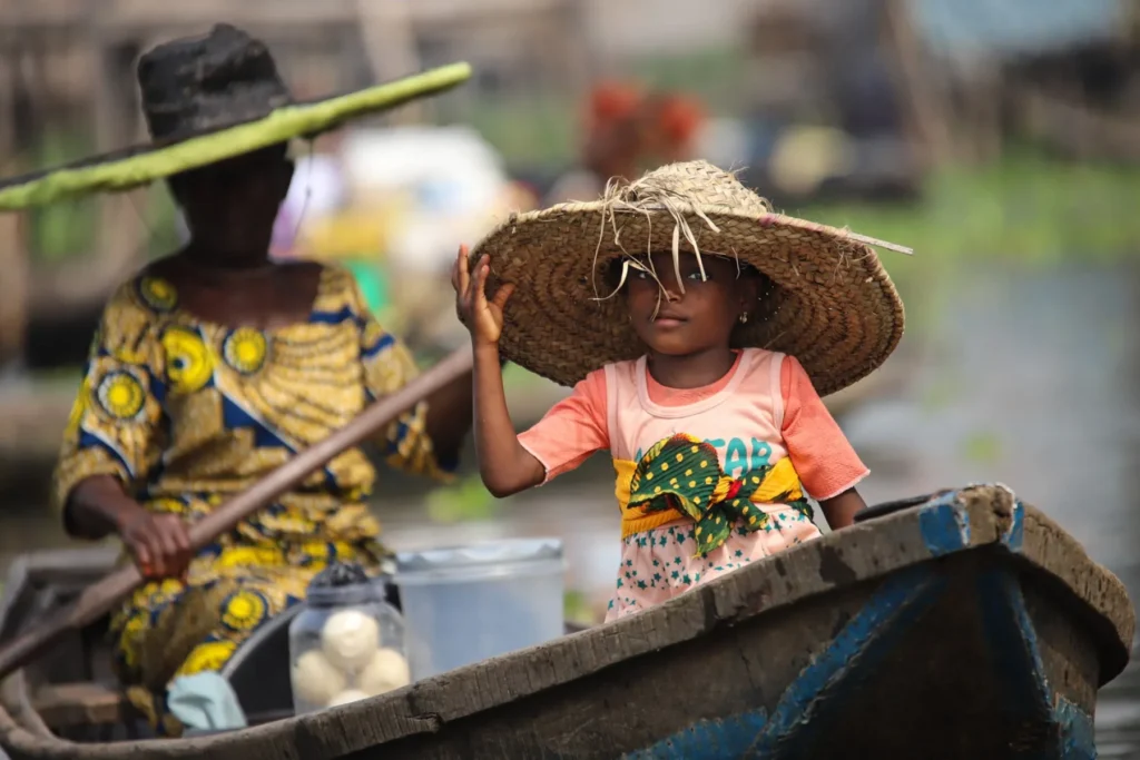 A woman and child crossing a Togo lake by boat